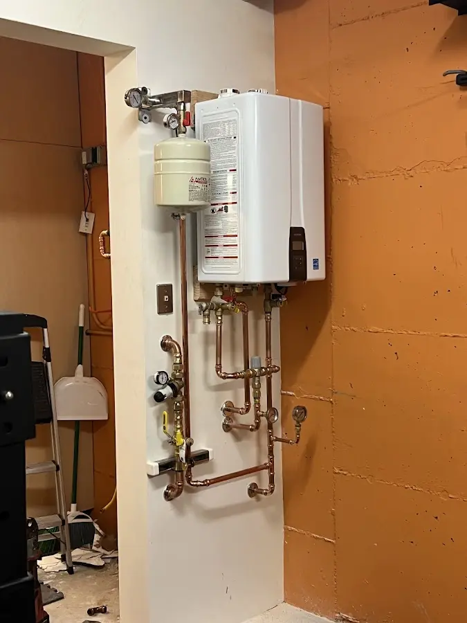 Plumbing technician inspecting water heater connections in Lake Ridge